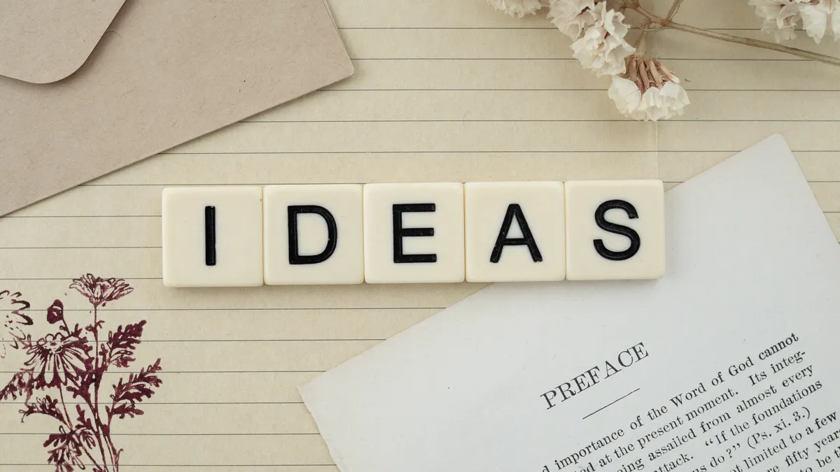 Letter tiles spelling IDEAS on a notebook