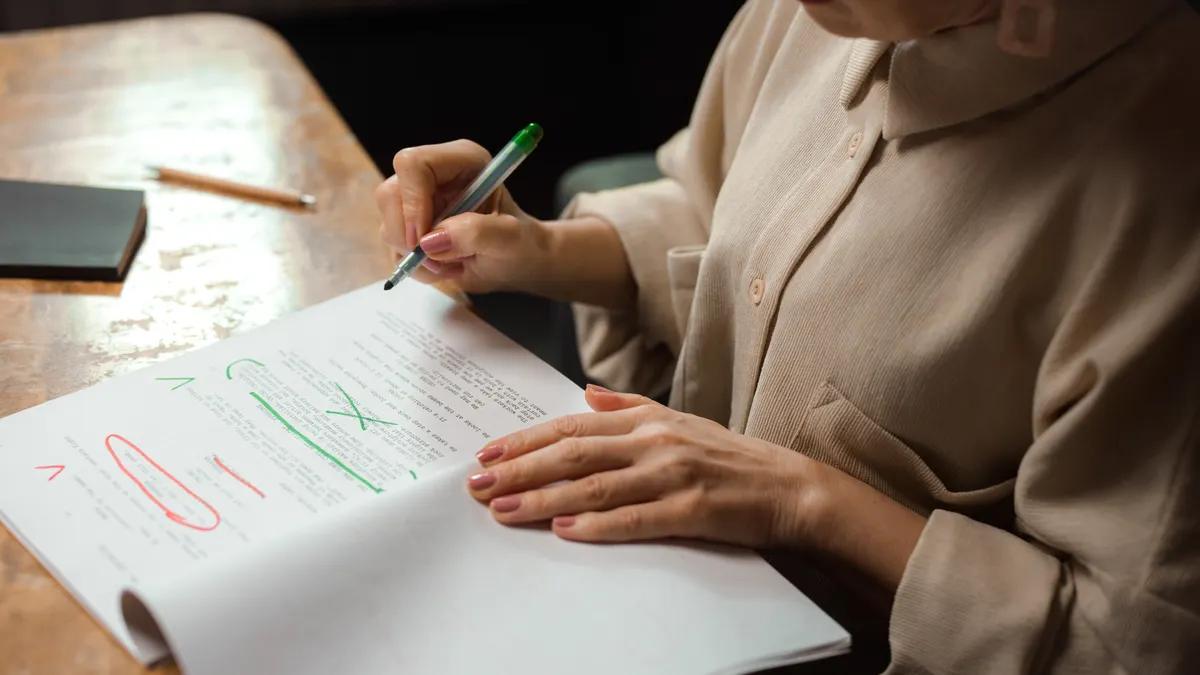 How to build SEO approval checkpoints for AI-written content Person marking up a document with a pen